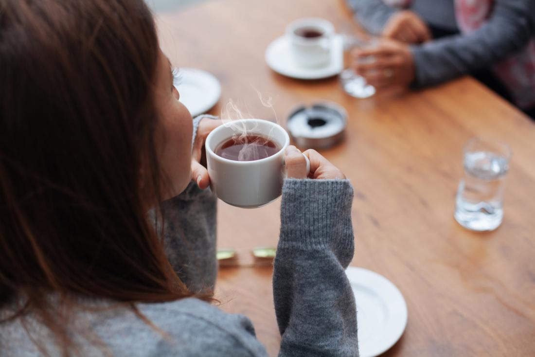 woman drinking hot tea in cafe.